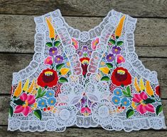 Famous Kalocsa lace (Richelieu) vest with authentic Hungarian pattern. High quality hand-embroidered work with lot of work Bust: 35 inch Lenght: 15,5 inch If you are interested in other sizes, please write to me.  Hand washes only. If you are buying several pieces I can combine postage at the time of mailing. If you have any question please don't hesitate to contact me For vintage hungarian emboridery please visit our other shop: https://www.etsy.com/shop/TreasuryCoffer?ref=l2-shopheader-name Bohemian Sleeveless Vest With Floral Embroidery, Festive Folk Vest With Floral Embroidery, Folk Style Multicolor Vest With Floral Embroidery, Bohemian Multicolor Floral Embroidered Vest, Sleeveless Folk Vest With Floral Embroidery, Waistcoat Pattern, Floral Vests, Lace Vest, Vest Outfits