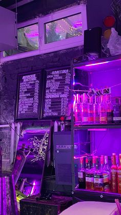 a bar with purple lighting and menus on the wall