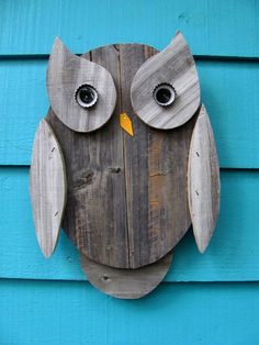 an owl made out of wooden planks on a blue wall