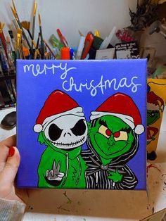 a hand holding up a christmas card with two cartoon characters