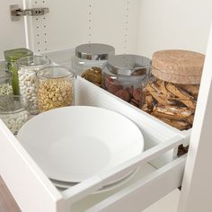 bowls and plates are stacked on top of each other in the kitchen cupboards,