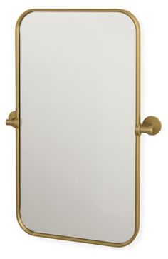 a gold framed mirror sitting on top of a white wall next to a faucet