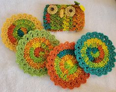 four crocheted coasters on a white towel with an owl design in the center