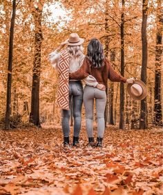 two women standing in the woods with their backs to each other