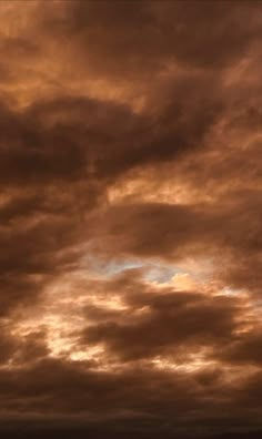 an airplane is flying in the sky at sunset or dawn with some clouds above it