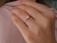 a woman's hand with a diamond ring on it