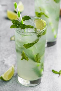 a mojito with mint and lime in a glass next to ice cubes