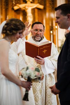 a man and woman standing in front of a priest