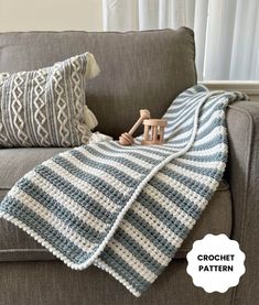 a crocheted blanket sitting on top of a couch next to a wooden toy