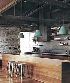 an image of a kitchen with stools in the foreground and brick wall behind it