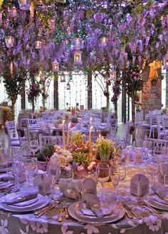 the table is set with purple flowers and candles