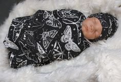 a baby doll that is laying down on a white furnishing with black and white designs