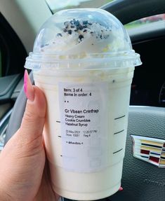 a person holding up a cup of ice cream in their hand with the label on it