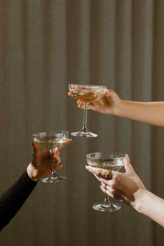 four people holding wine glasses in their hands