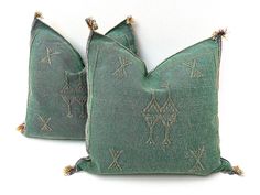 two green pillows with decorative designs on them