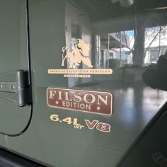 the emblem on the side of a green vehicle