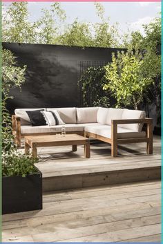 a couch sitting on top of a wooden floor next to a plant filled garden area