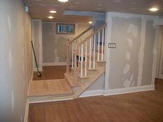 an empty room with wood floors and white walls that have been painted basements on them