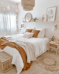 a bedroom with white walls and wooden flooring is decorated in neutral tones, such as beige