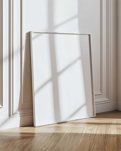 an empty photo frame sitting on the floor in front of a window