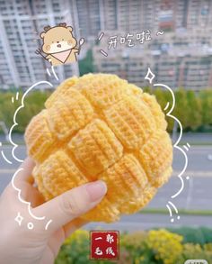 a person holding up a waffle in front of a cityscape with chinese characters on it