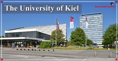 the university of kiell is located in front of two tall buildings with flags flying from them