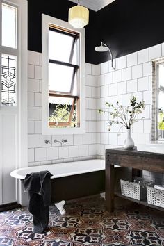 a bath room with a tub a sink and a mirror on the wall in it