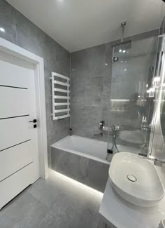 a white sink sitting next to a bath tub in a bathroom