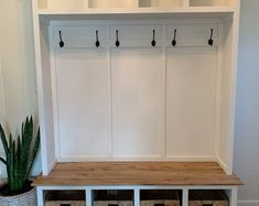 an entryway bench with two cubbys and a potted cacti