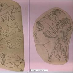 two drawings of women's heads on display in a glass case with pink background