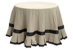 a round table with a black and white stripe on the skirted tablecloths