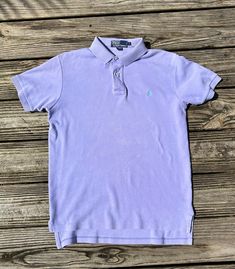 You know the original owner of this shirt was THE BOMB. Vintage pastel purple Ralph Lauren Polo shirt. Size medium but runs a little big so it's more like a large. Slight discoloration under buttons but it's very light. Freshly dry cleaned. Purple Short Sleeve Top With Button Closure, Classic Fitted Purple Polo Shirt, Purple Fitted Collared Polo Shirt, Classic Purple Summer Shirt, Classic Purple Cotton Tops, Fitted Purple Collared Polo Shirt, Vintage Purple Tops With Button Closure, Purple Cotton Classic Style Tops, Classic Purple Short Sleeve Polo Shirt