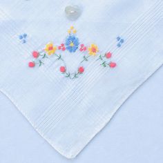 "One of a kind new and unused hand embroidered \"Bridesmaid\" vintage fine white cotton lawn handkerchief. The handkerchief has a machine embroidered posy of gorgeous red, yellow and blue flowers in one corner. The sides of the handkerchief are finished off with a machine edge. I have used 100% colour fast contrasting blue embroidery thread for the \"Bridesmaid\" inscription on this gorgeous handkerchief. This lovely keepsake is finished off with a natural mother of pearl heart shaped button. Th Floral Embroidered Handkerchiefs For Spring Wedding, Blue Embroidered Handkerchiefs For Wedding, Blue Embroidered Handkerchief For Wedding, Blue Embroidered Wedding Handkerchief, Spring Wedding Handkerchiefs With Floral Embroidery, Vintage Blue Handkerchiefs With Floral Embroidery, Blue Vintage Handkerchiefs With Floral Embroidery, Blue Cotton Handkerchiefs For Wedding, Yellow And Blue Flowers