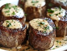 the steaks are covered in sauce and garnished with parsley on top