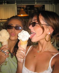 two beautiful women eating ice cream cones together