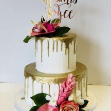 a three tiered cake decorated with flowers and the word love is spelled on top