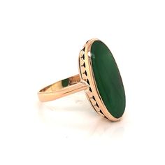 Rich in history and folklore, jade is the iconic green gemstone at the center of the most fabulous jewelry pieces. This one of a kind Mid-Century cocktail ring features an oval cut green jade in 14 karat yellow gold. The center jade has a deep hunter green hue and is polished into an oval-shaped cabochon. Colorful and youthful in style, the green jade rests in a vintage basket and fitted on a dainty 14K yellow gold ring. The shoulders of the band are reverse tapered. Every detail of the ring has Luxury Jade Rings In Fine Jewelry Style, Jade Stone Ring, Jade Rings For Women, Elongated Oval, Vintage Basket, Metal Shop, Jade Ring, Fabulous Jewelry, Jade Stone