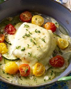 a pan filled with chicken, tomatoes and cucumbers