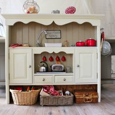 a white cabinet with baskets underneath it