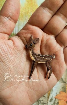 a small deer figurine sitting in someone's hand