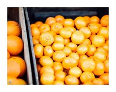 oranges are stacked in bins and ready to be picked from the market or sold