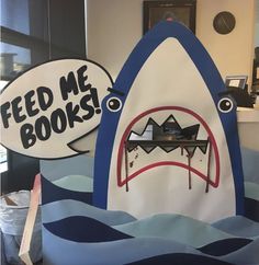 a shark book bag with a sign that says feed me books