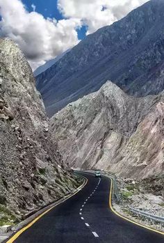 an empty road in the middle of mountains