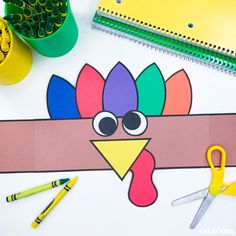 a paper turkey with scissors and crayons next to it