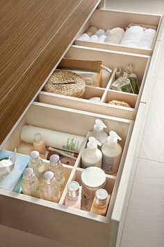 an open drawer with many items in it, including soaps and lotion bottles