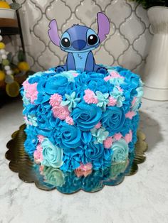 a blue and pink cake sitting on top of a table