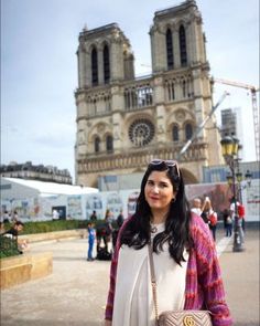 a woman standing in front of a large cathedral