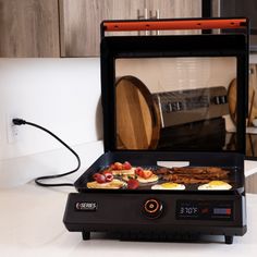 an electric grill with food cooking on it in the middle of a kitchen countertop