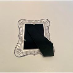 a black tie laying on top of a silver frame