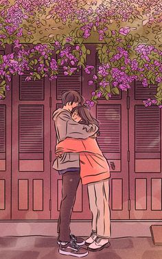 two people embracing each other in front of purple flowers on a building with wooden doors